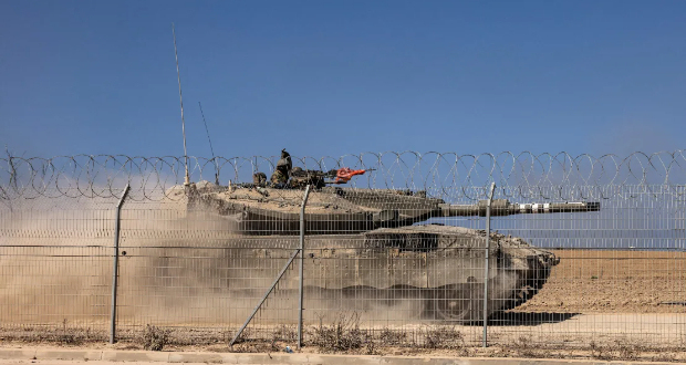 An Israeli Merkava tank drives past a fence near Kibbutz Beeri, close to the border with Gaza on October 20, 2023. Ronaldo Schemidt/AFP/Getty Images