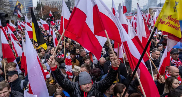 Participants in Poland's Independence Day march organised by nationalist groups wave Polish flags in Warsaw, Poland on November 11, 2023 [Wojtek Radwanski/AFP]