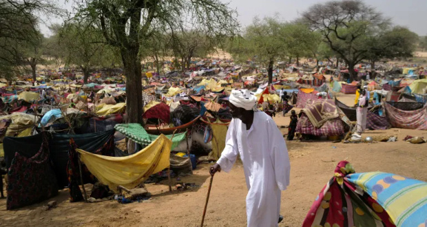 A displaced Sudanese man who fled Darfur and was previously internally displaced in Sudan walks past makeshift shelters in Borota, Chad near the Sudan-Chad border on May 13, 2023 [Zohra Bensemra/Reuters]