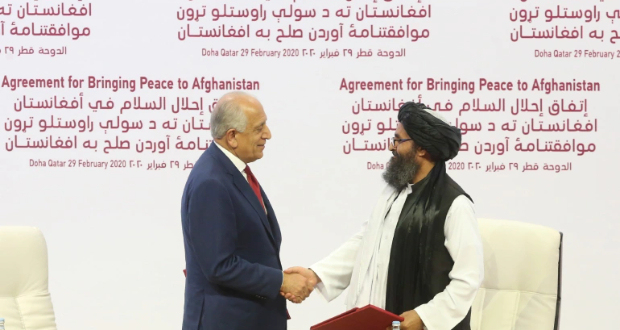 Former US envoy Zalmay Khalilzad shakes hands with Taliban leader Mullah Abdul Ghani Baradar after signing a February 2020 peace agreement in Qatar [File: Hussein Sayed/The Associated Press]