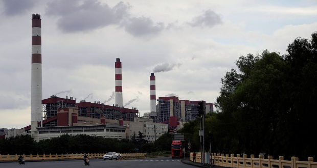 People drive past a coal-fired power plant in Shanghai, China October 21, 2021. REUTERS/Aly Song