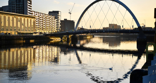 A swan floats as the early morning sun shines on the River Clyde and the venue for the UN Climate Change Conference (COP26) in Glasgow, Scotland Britain, November 10, 2021. REUTERS/Dylan Martinez