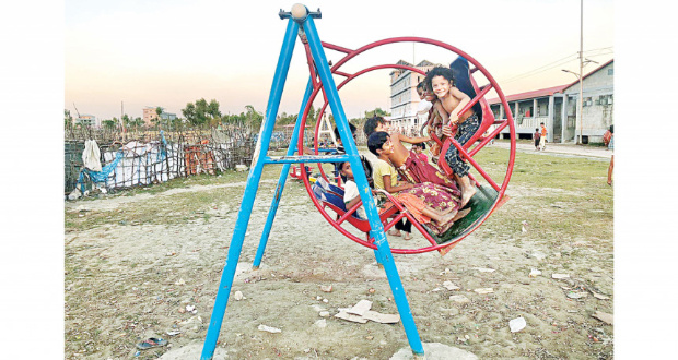 A group of children enjoying themselves on a large swing at a playground in Bhasan Char. 