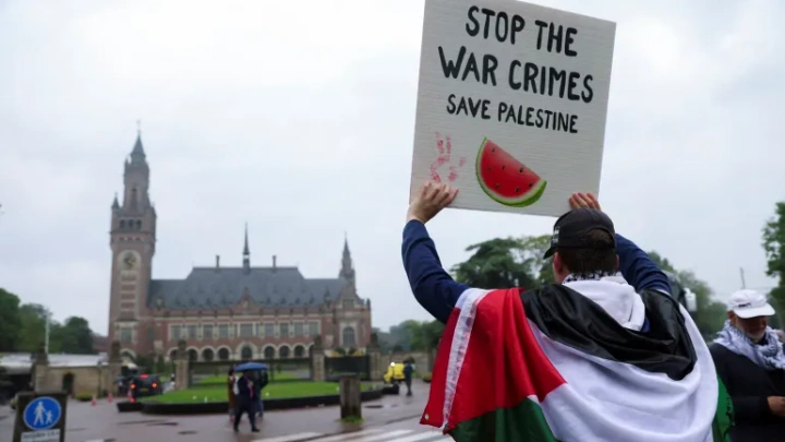 Outside the International Court of Justice, a protester draped in a Palestinian flag calls for an end to Israel's war on Gaza [File: Johanna Geron/Reuters]