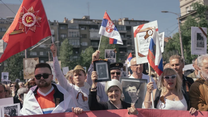 FILE PHOTO: People carry portraits of World War II soldiers during the 'Immortal Regiment' march on May 9, 2022 in Belgrade, Serbia. ©  Vladimir Zivojinovic / Getty Images