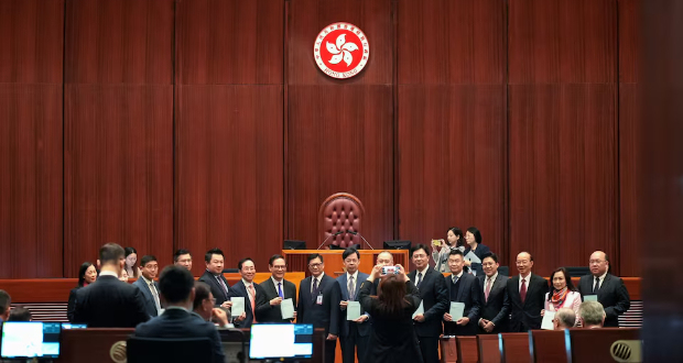  Hong Kong security chief Chris Tang poses for photos with lawmakers as they hold drafts of the Safeguarding National Security Bill, also referred to as Basic Law Article 23, before the second reading at Hong Kong’s Legislative Council, in Hong Kong, China March 19, 2024. REUTERS/Joyce Zhou